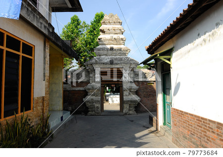 JOGJAKARTA, INDONESIA -JUNE 12, 2014: Entrance arch at old Masjid Besar Mataram Kotagede, Jogjakarta Indonesia. The arch was made from brick and hand made carving stone in traditional Balinese Style JOGJAKARTA, INDONESIA -JUNE 12, 2014: Entrance arch at old Masjid Besar Mataram Kotagede, Jogjakarta Indonesia. The arch was made from brick and hand made carving stone in traditional Balinese Style 79773684