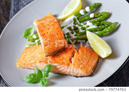 roasted salmon fillets with lemon and asparagus 79774763