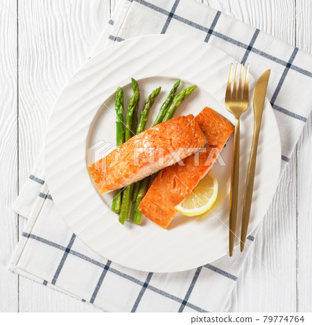 roast salmon fillets with lemon and asparagus 79774764