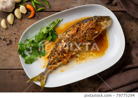 Fried fish with sweet chili sauce.Deep Fried Hamachi fish (Black-banded trevally) Topped with thai sweet and sour sauce.Top view 79775294