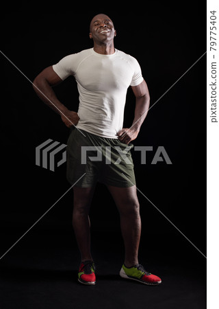African American man standing looking at camera with fists on waist 79775404