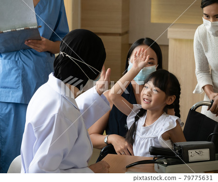 The medical team is greeting cute girl patients to relieve anxiety as they are treated in the hospital 79775631