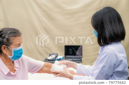The doctor's is making a wound on the arm of an elderly woman who has an accident The doctor's is making a wound on the arm of an elderly woman who has an accident 79775682