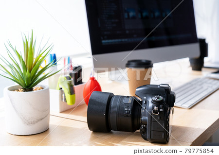 Digital SLR camera placed next to the PC monitor 79775854