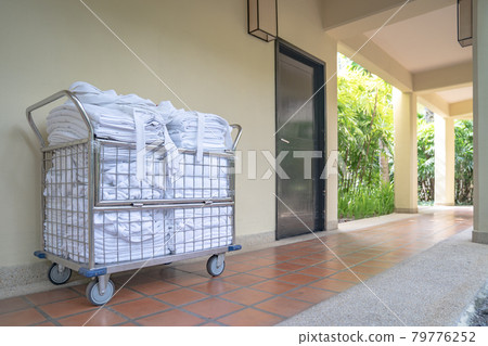 hotel maid trolley parking front of the room with clean towel and bathrobes ready to change and make up the room. hotel maid trolley parking front of the room with clean towel and bathrobes ready to change and make up the room. 79776252