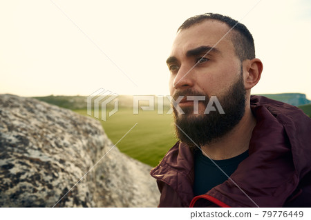 Young bearded man portrait outdoors in the mountains Young bearded man portrait outdoors in the mountains 79776449