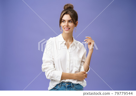 Feminine and stylish modern charming girl with gapped teeth and pimple posing in trendy white blouse and round earrings gazing left charmed and sensual with cute smile over purple background Feminine and stylish modern charming girl with gapped teeth and pimple posing in trendy white blouse and round earrings gazing left charmed and sensual with cute smile over purple background 79779544