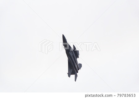 A scene of an F-15 fighter passing overhead while making a sharp turn A scene of an F-15 fighter passing overhead while making a sharp turn 79783653