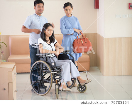 Hospital staff pushing a woman in a wheelchair to check for a headache at the hospital examination department. 79785164