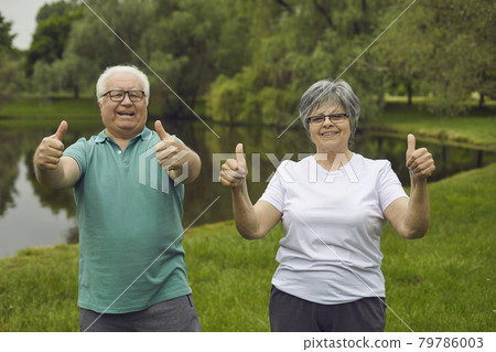 Portrait of happy senior couple giving thumbs up after doing sports exercise in nature 79786003