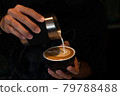 Pouring latte art into the black coffee cup 79788488