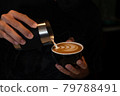 Pouring latte art into the black coffee cup 79788491