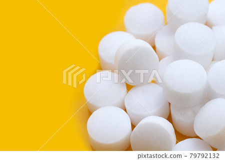 Naphthalene mothballs on yellow backgrond. Naphthalene mothballs on yellow backgrond. 79792132