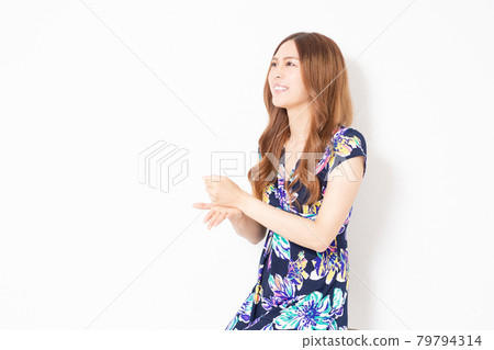 一位身穿藍色連身裙的年輕女子,在白牆前做出令人信服的手勢 一位身穿藍色連身裙的年輕女子,在白牆前做出令人信服的手勢 79794314