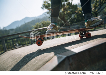 Asian woman skateboarder skateboarding at skatepark Asian woman skateboarder skateboarding at skatepark 79796615