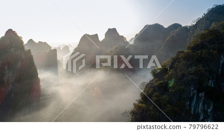 Aerial of beautiful sunrise over foggy karst mountain peak landscape Aerial of beautiful sunrise over foggy karst mountain peak landscape 79796622