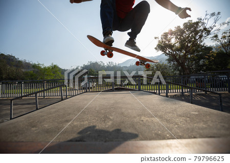 Young skateboarder legs skateboarding at skatepark 79796625