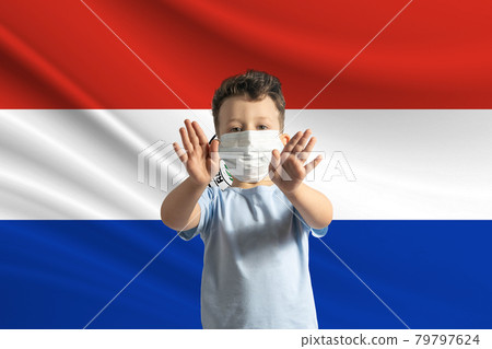 Little white boy in a protective mask on the background of the flag of Paraguay. Makes a stop sign with his hands, stay at home Paraguay 79797624
