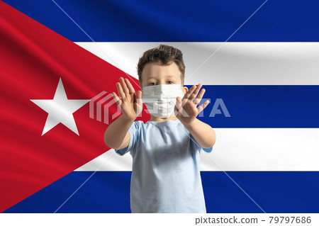 Little white boy in a protective mask on the background of the flag of Cuba Makes a stop sign with his hands, stay at home Cuba Little white boy in a protective mask on the background of the flag of Cuba Makes a stop sign with his hands, stay at home Cuba 79797686