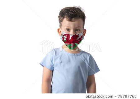 Respirator with flag of Wales. White boy puts on medical face mask isolated on white background Respirator with flag of Wales. White boy puts on medical face mask isolated on white background 79797763