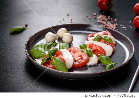 Italian caprese salad with sliced tomatoes, mozzarella cheese, basil, olive oil Italian caprese salad with sliced tomatoes, mozzarella cheese, basil, olive oil 79798155