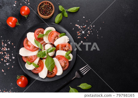Italian caprese salad with sliced tomatoes, mozzarella cheese, basil, olive oil Italian caprese salad with sliced tomatoes, mozzarella cheese, basil, olive oil 79798165