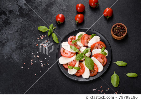 Italian caprese salad with sliced tomatoes, mozzarella cheese, basil, olive oil Italian caprese salad with sliced tomatoes, mozzarella cheese, basil, olive oil 79798180
