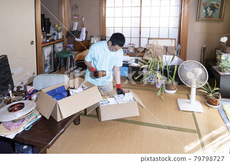 Male worker organizing a messy room 79798727