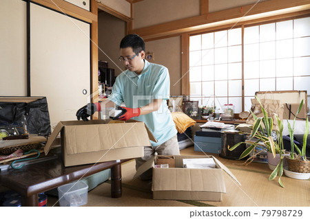 Male worker organizing a messy room 79798729