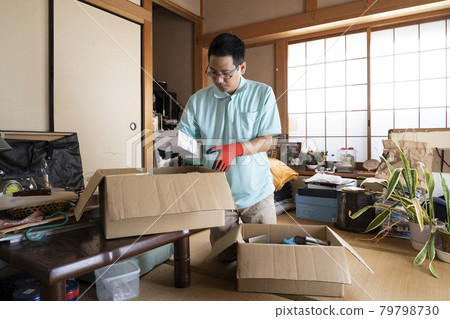 Male worker organizing a messy room 79798730