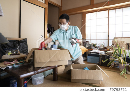 Male worker organizing a messy room 79798731