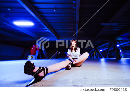 A cute girl chatting on the ground in the parking lot in the middle of the night A cute girl chatting on the ground in the parking lot in the middle of the night 79800418