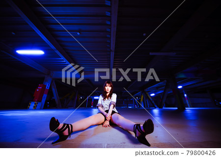 A cute girl chatting on the ground in the parking lot in the middle of the night A cute girl chatting on the ground in the parking lot in the middle of the night 79800426