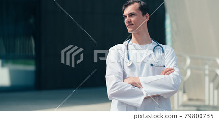 tired young doctor standing near the entrance to the hospital . 79800735