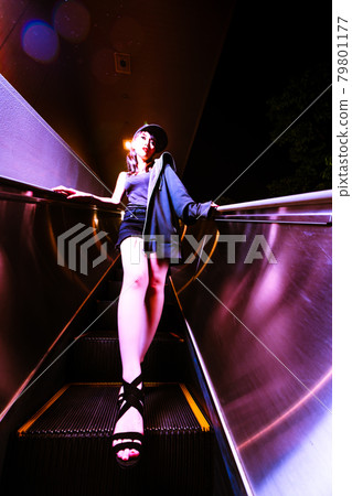一個美麗的女人在自動扶梯上,看起來像一個停止的不同空間 一個美麗的女人在自動扶梯上,看起來像一個停止的不同空間 79801177