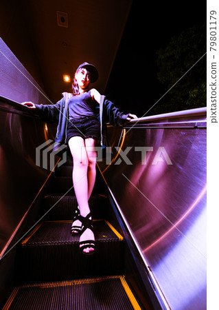 一個美麗的女人在自動扶梯上,看起來像一個停止的不同空間 一個美麗的女人在自動扶梯上,看起來像一個停止的不同空間 79801179