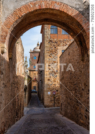 Narrow alley with old stone buildings at Caceres, Extremadura, Spain. Narrow alley with old stone buildings at Caceres, Extremadura, Spain. 79802308