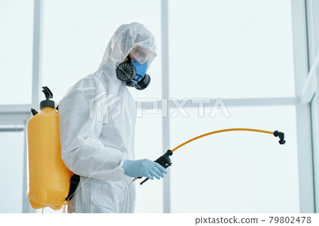 man in a bacteriological protection suit standing in the office . 79802478