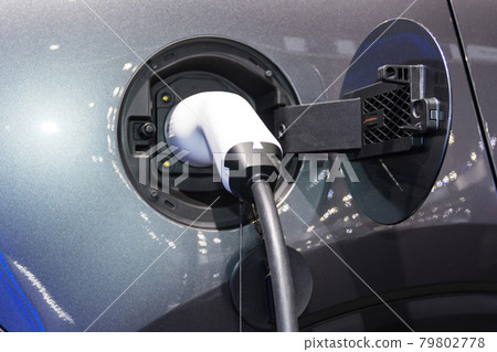 the charging the battery for the car new Automotive Innovations the power supply plugged into an electric car being charged, concept of energy innovation. 79802778
