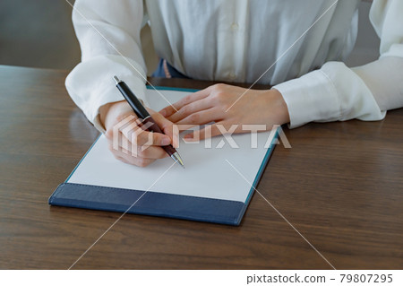 一位年輕女子的手在剪貼板上填寫問卷 79807295
