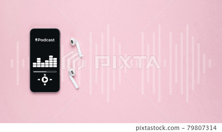 Podcast background. Mobile smartphone screen with podcast application, sound headphones. Audio voice with radio microphone on pink. Recording studio or podcasting banner with copy space. 79807314