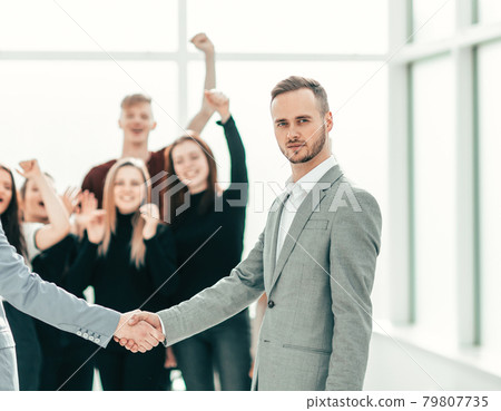 serious young men shaking hands. concept of cooperation 79807735