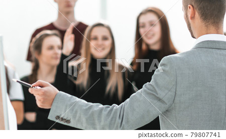 rear view. serious Manager pointing at flipchart rear view. serious Manager pointing at flipchart 79807741