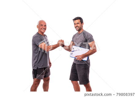 Fitness trainer with a workout pad shakes hands with a retired man in sports uniform. On a white isolated background. 79808397