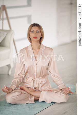 Beautiful lady is meditating on floor in her 79810212