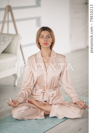 Beautiful lady is meditating on floor in her 79810213