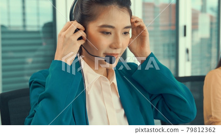 Businesswoman wearing headset working actively in office 79812362