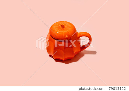 Ceramic Coffee tea soup cup as pumpkin on pink. Halloween concept, hard shadow, minimal Ceramic Coffee tea soup cup as pumpkin on pink. Halloween concept, hard shadow, minimal 79813122