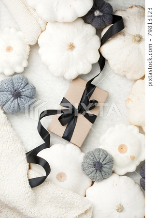 Stylish flat lay with uxury paper craft gift box and black satin ribbon bow on natural pumpkin squash background with copy space, discount, sale flyer, thanksgiving, harvesting monochrome concept Stylish flat lay with uxury paper craft gift box and black satin ribbon bow on natural pumpkin squash background with copy space, discount, sale flyer, thanksgiving, harvesting monochrome concept 79813123