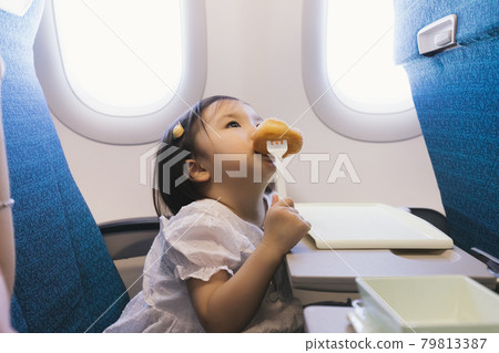 Baby eats on airplane 79813387